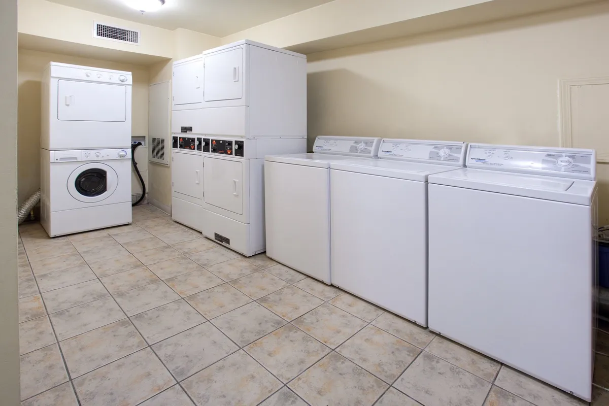 A clean, efficient laundry space with a washing machine and dryer, complemented by organized shelves and laundry supplies. The layout suggests ease of use and modern convenience, echoing the comfort of having in-unit laundry while traveling.
